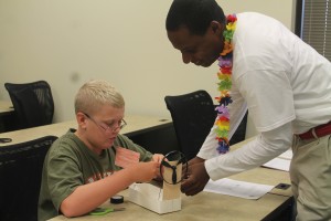 Engineering for Kids Camp Instructor Maurice Reid discusses the boat's design with Gavin Mosteller of Dallas.