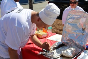 Seriously Smokin’ team member Dustin Saghy checks the temperature of his team's ribs.