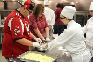 From left SETS students, Carson Boyd and Madison Johnson build an apple crisp with the help of CTC Culinary Arts student Sara Sheets.