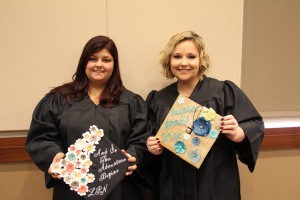 Woodstock resident Delaina Snarski and Powder Springs resident Brittany Thompson show off their graduation caps.
