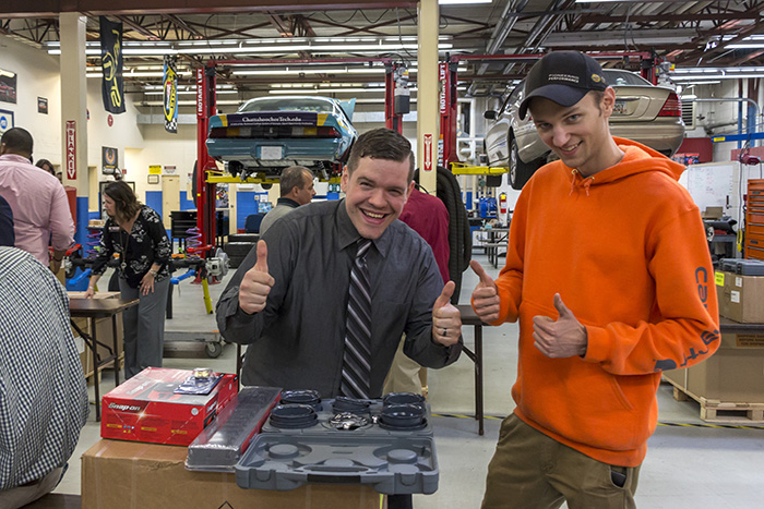 Two male students with thumbs up behind new tools following Mike Peterson Scholarship ceremony