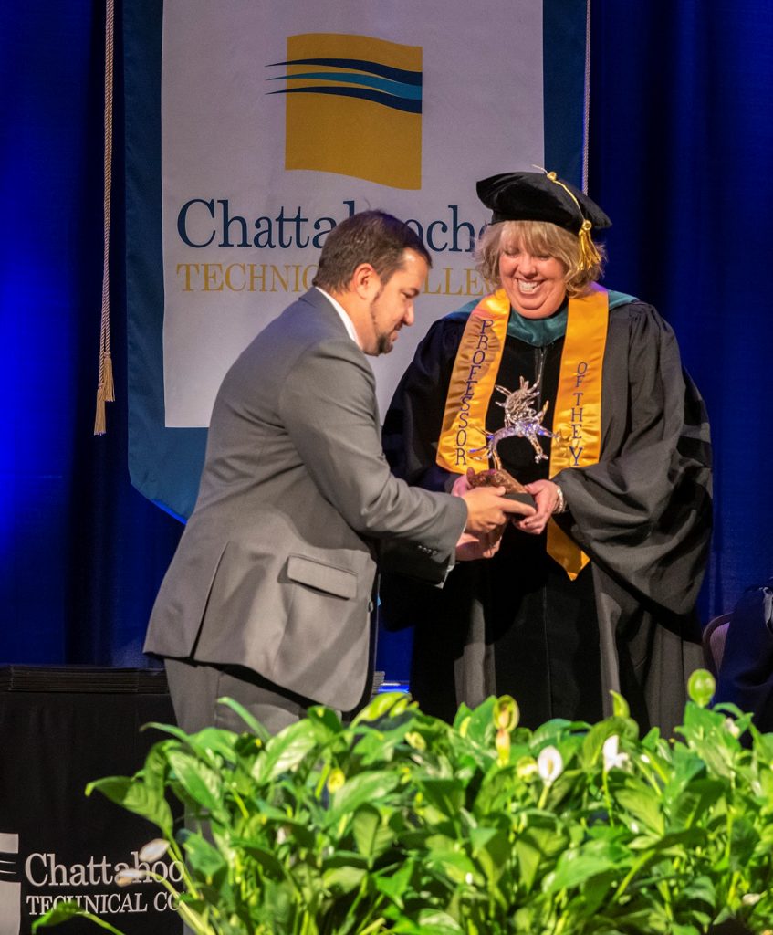 Chattahoochee Tech Foundation Board of Trustees Chairman Jason Anavitarte presents an award to PTA Program Director Stephanie Puffer, who is the college’s 2019 Rick Perkins Instructor of the Year.