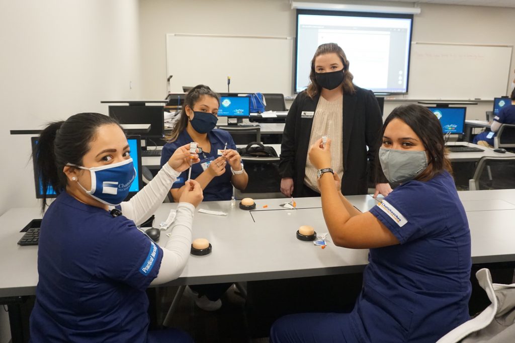 Shown here, l-r, with CTC Nursing Instructor Ayla Roberts, who is standing, are students Bianca Pineda, Yesica Patino, and Darlin Reyes-Cruz.