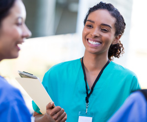 A nurse smiling with another nurse