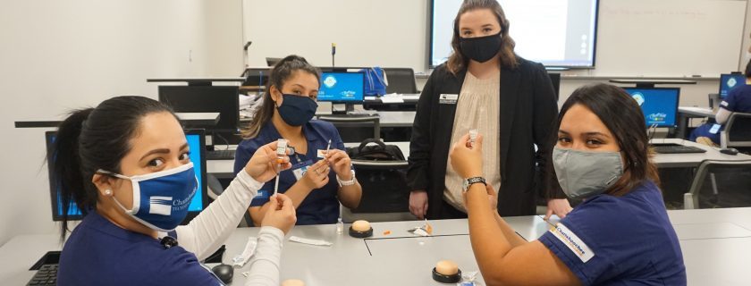 Three masked women in medical attire