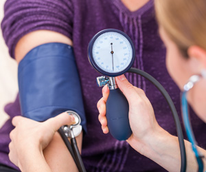 A woman checking pulse on a patient