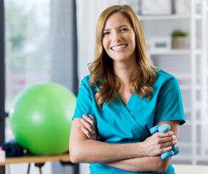 A smiling woman with a medicine ball