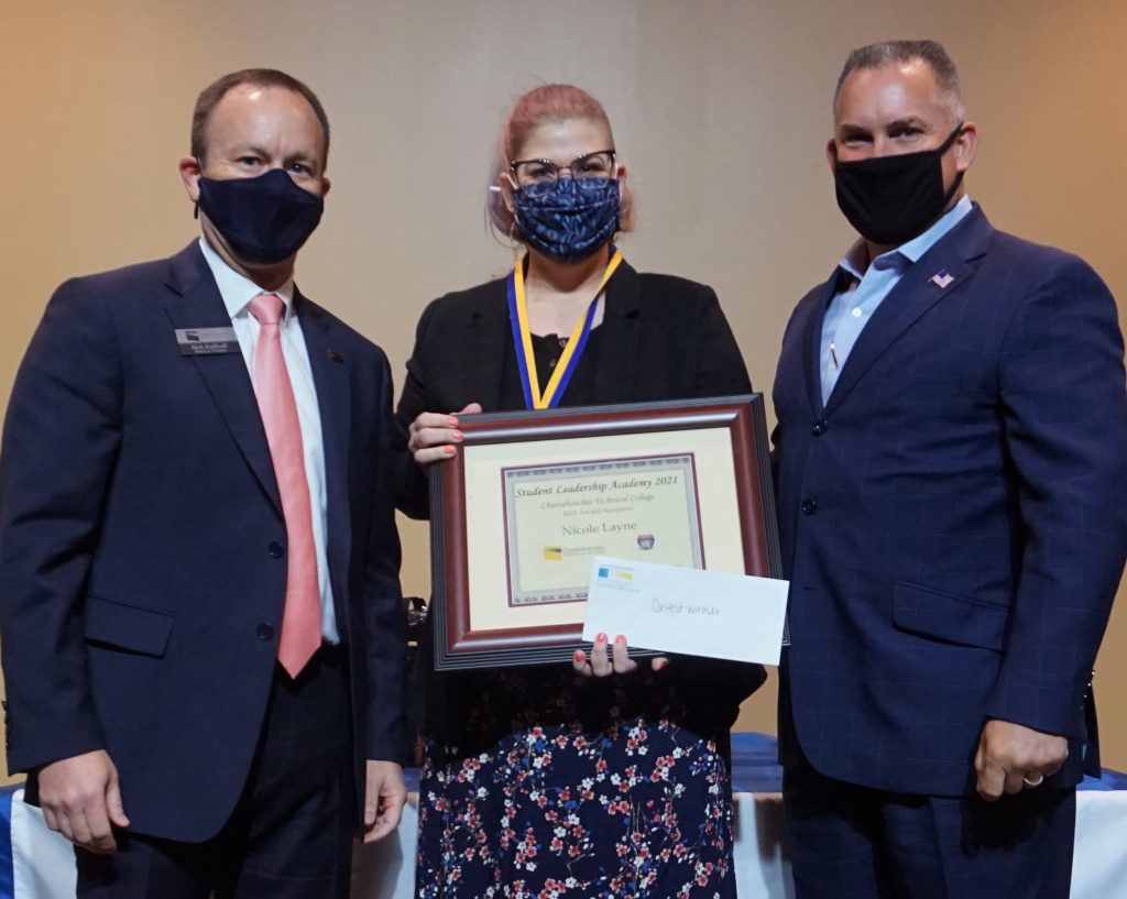 Shown here are Board of Trustees Vice Chair Rick Kollhoff, student essay contest winner Nicole Layne, and Student Leadership Academy sponsor Drew Tutton of Open Roads Complete RV.