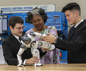 An instructor and two students building a robot
