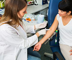 Phlebotomist preparing to draw blood sample from a patient's arm