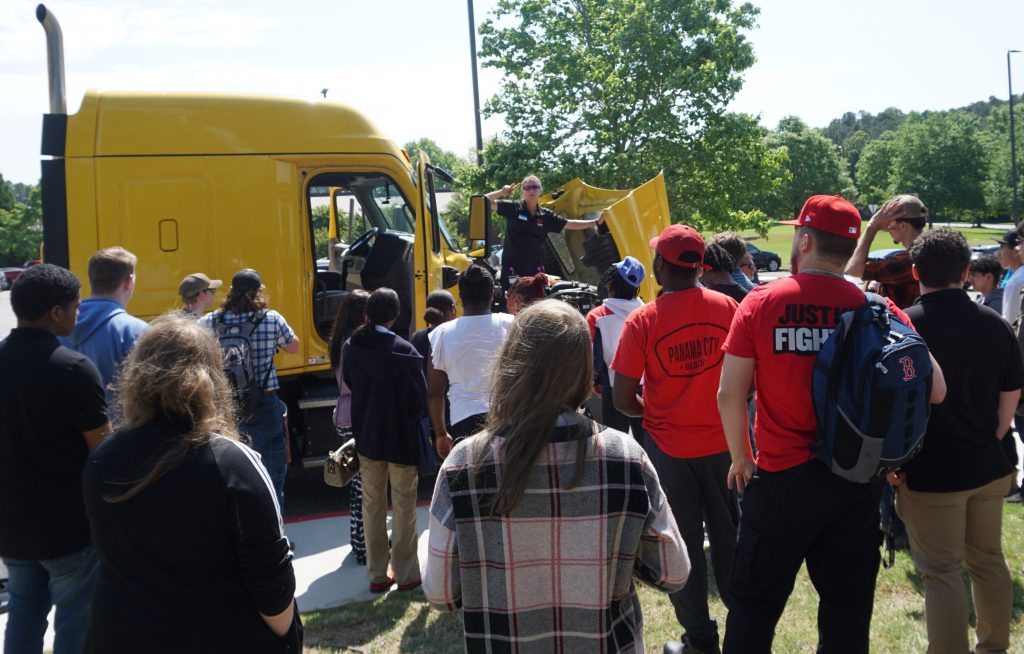 shown here listening to a presentation from Chattahoochee Tech Commercial Truck Driving Instructor Katina Barbee.