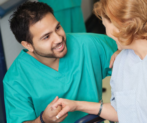 A smiling male nurse helping a patient