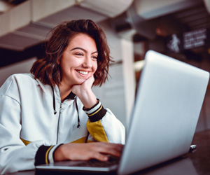 A woman smiling and using a laptop