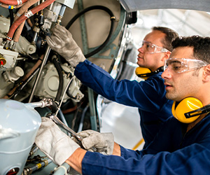 Two aviation mechanics working on a plane