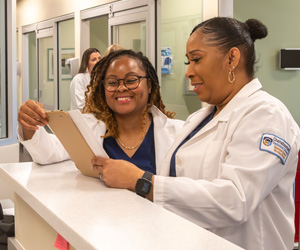 Nursing students smiling and working in the lab