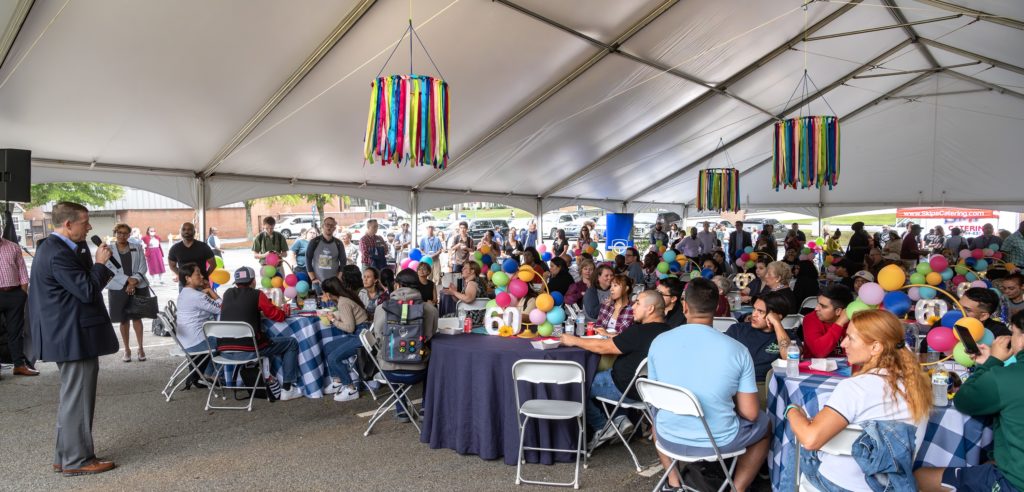 TCSG Commissioner Greg Dozier speaks to those gathered under the tent for the college's 60th anniversary celebration.