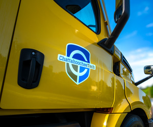 Close up of a yellow tractor trailer truck's door with the Chattahoochee Tech logo on it