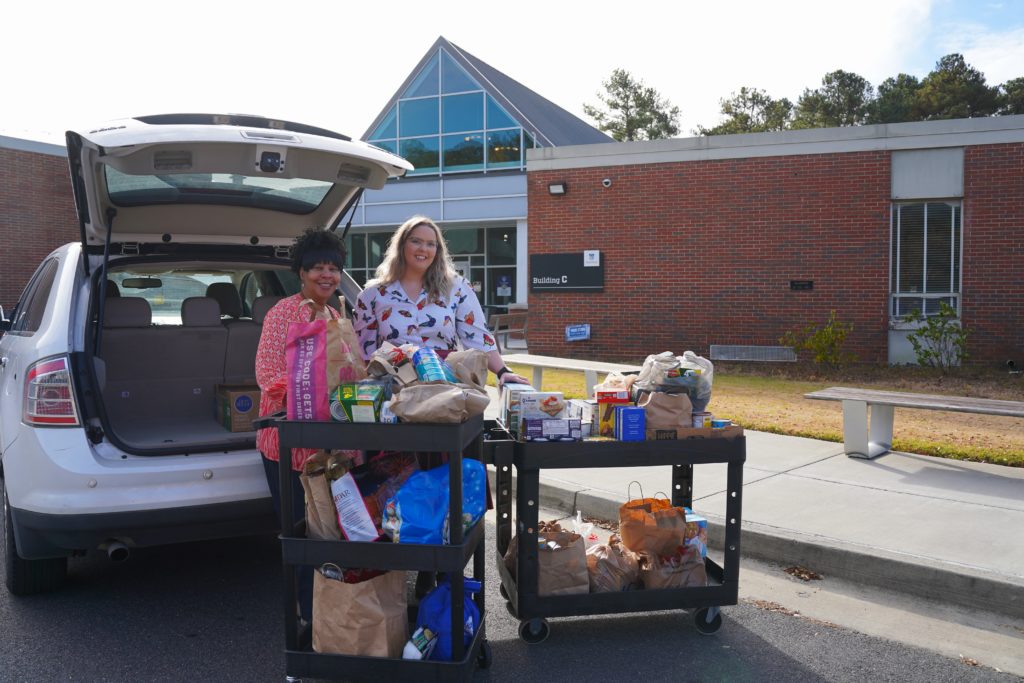 Donations are unloaded from a vehicle onto two carts for the Golden Eagle Food Pantry.