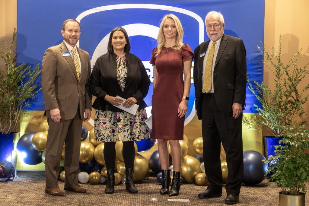 Board of Trustees Chair is shown on stage with the GOAL and RPA winner and Dr. Ron Newcomb