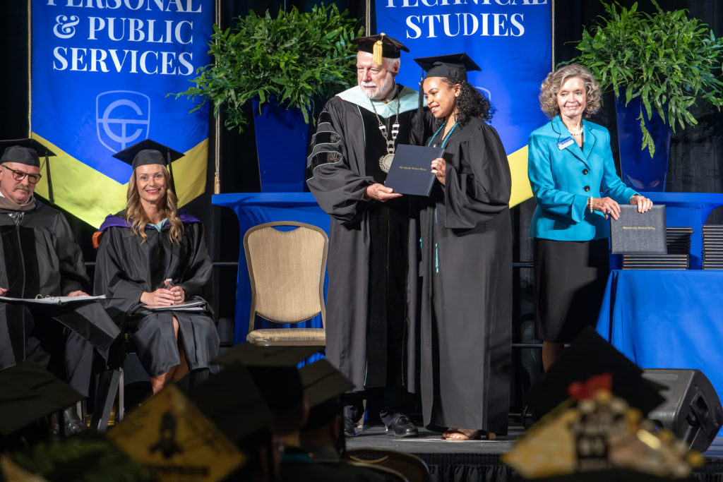 Dr. Newcomb presents diploma to Chatt Tech graduate on stage