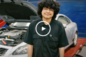 Dual Achievement student smiling in a mechanic shop