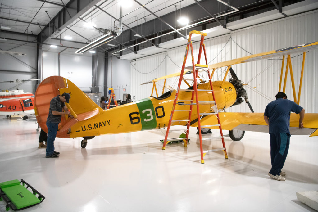 Students with ladder working on wings of the N3N airplane